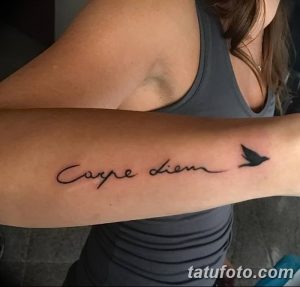 Фото тату с надписью 'Carpe Diem' и изображением летящей птицы, выполненной в минималистичном стиле, выглядит легко и воздушно.