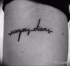 Фото тату с надписью 'Carpe Diem' на боку, выполненной красивым, рукописным шрифтом. Элегантный рисунок татуировки.