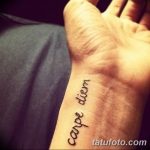 Фото тату с надписью 'Carpe Diem' на верхней части стопы, выполненной простым шрифтом. Минималистичный рисунок татуировки.