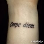 Фото простой татуировки надписи 'Carpe Diem' на запястье, выполненной черным цветом. Лаконичный и стильный эскиз тату для тех, кто ценит минимализм.