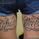 Фото тату надписи "Carpe Diem" на бедрах женщины. Черно-серый рисунок татуировки, выполненный каллиграфическим шрифтом с декоративными элементами.