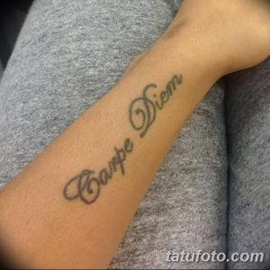 Фото тату надписи "Carpe Diem" на запястье. Черно-серый рисунок татуировки, выполненный простым шрифтом.