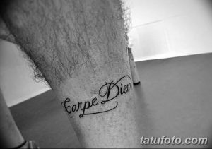 Фотография татуировки с надписью 'Carpe Diem' на икре мужчины. Черный контур, каллиграфический шрифт, лаконичный дизайн.