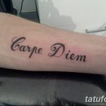 Фото тату с надписью 'Carpe Diem' на предплечье, выполненной классическим шрифтом. Простой и элегантный эскиз тату для ценителей минимализма.