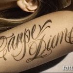 Фото тату с надписью 'Carpe Diem' на плече, выполненной в витиеватом стиле с использованием теней. Яркий эскиз тату для тех, кто любит выразительность.
