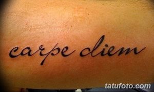 Фото тату с надписью 'Carpe Diem' на животе, выполненной простым, но элегантным шрифтом. Минималистичный эскиз тату для любителей лаконичности.