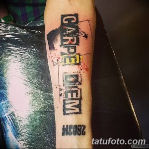 Фото татуировки 'Carpe Diem' в стиле граффити на предплечье. Яркие цвета, брызги краски, динамичный дизайн, современный стиль.