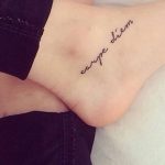 Фото минималистичной татуировки 'Carpe Diem' на запястье. Тонкие линии, простой шрифт, черно-белая татуировка, лаконичный дизайн.