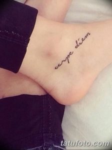 Фото минималистичной татуировки 'Carpe Diem' на запястье. Тонкие линии, простой шрифт, черно-белая татуировка, лаконичный дизайн.
