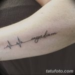 Фото тату: надпись 'Carpe Diem' в виде кардиограммы на предплечье. Минималистичный рисунок татуировки, выполненный в черном цвете.