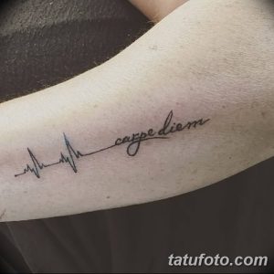 Фото тату: надпись 'Carpe Diem' в виде кардиограммы на предплечье. Минималистичный рисунок татуировки, выполненный в черном цвете.