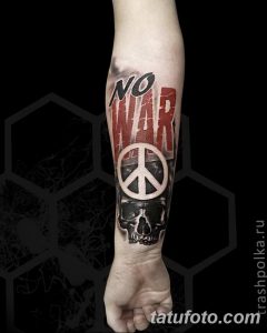 Фото тату: татуировка на предплечье с надписью "NO WAR", символом мира и изображением черепа.