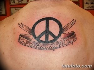 Фото тату символа мира с надписью "It's A Beautiful Day" на спине. Классический дизайн с позитивным посланием.