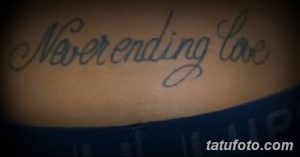 Фото тату надписи 'Neverending Love' на груди. Элегантный шрифт, выполненный в черно-серых тонах, символизирует вечную любовь и преданность.