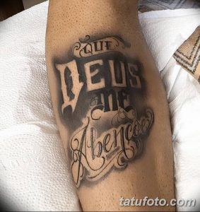 Фото тату с надписью 'Que Deus Me Abençoe' (Да благословит Бог меня) на руке, выполненное в стиле blackwork с использованием теней и градиентов.