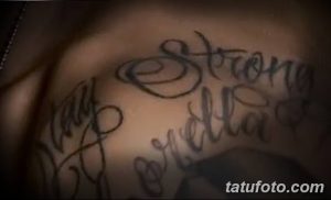Фото тату надписи 'Strong Bella' на теле. Черная надпись, выполненная каллиграфическим шрифтом, выглядит стильно и выразительно.