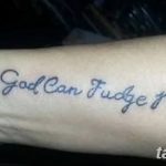 Фото простой тату надписи 'Only God Can Judge Me' черным цветом, выполненной на запястье. Минималистичный рисунок татуировки.