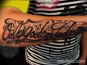 Фото тату надписи 'Only God Can Judge Me' в стиле леттеринг, выполненной на предплечье. Детализированный рисунок татуировки с использованием черных чернил.