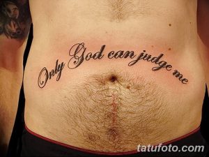 Фото тату надписи 'Only God Can Judge Me' на животе. Черно-серая татуировка, выполненная каллиграфическим шрифтом.