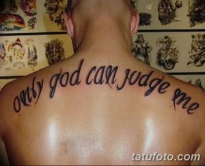 Фото тату надписи 'Only God Can Judge Me' на спине мужчины. Черно-белая татуировка, простой шрифт.