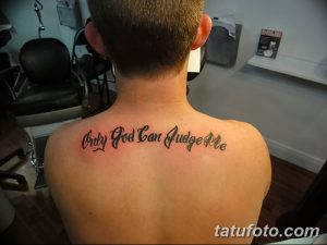 Фото тату надписи 'Only God Can Judge Me' на спине мужчины. Черно-белая татуировка, выполненная простым шрифтом.