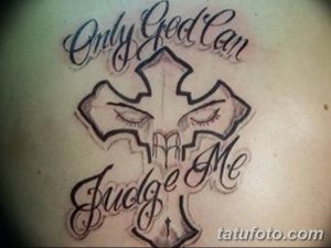 Фото тату на плече с изображением креста, стилизованного под череп. Надпись 'Only God Can Judge Me' обрамляет рисунок.