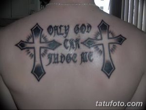 Татуировка с изображением двух крестов и надписью 'Only God Can Judge Me' на спине. Религиозный мотив и выражение веры.