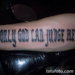 Черная татуировка надписью 'Only God Can Judge Me', выполненная в готическом стиле на руке. Строгий и выразительный дизайн для поклонников готики.