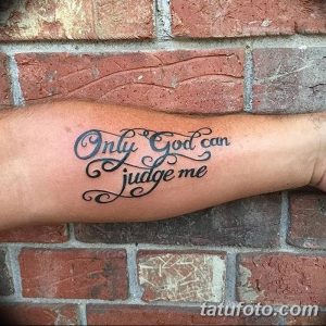 Фото татуировки на предплечье с надписью 'Only God Can Judge Me', выполненной изящным каллиграфическим шрифтом.