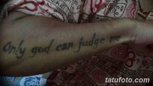 Фото тату с надписью 'Only God Can Judge Me', выполненной простым шрифтом на руке. Черно-белый рисунок татуировки.