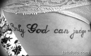 Фото тату на боку: простая надпись 'Only God Can Judge Me' каллиграфическим шрифтом. Черно-белая татуировка, минималистичный дизайн.
