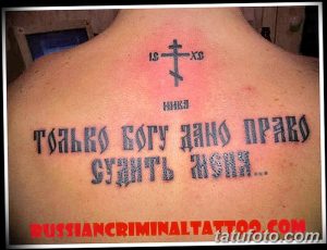 Фото тату надписи 'Только Богу дано судить меня' на мужской спине. Рисунок татуировки выполнен в традиционном стиле с использованием грубых линий и ярких цветов.