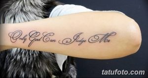 Фото тату надписи 'Only God Can Judge Me' на руке. Изящный каллиграфический шрифт, выполненный черными чернилами.