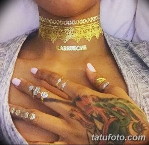 Фото тату с золотыми узорами и надписью "Ririuche" на груди и руке девушки. Изящные линии и орнаменты.