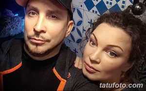 Фото мастера тату и его клиента: мастер сосредоточенно работает над татуировкой, демонстрируя профессионализм и опыт.