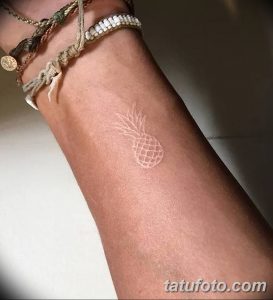 Фото белой татуировки на ноге: небольшой ананас, выполненный в технике white ink, выглядит свежо и оригинально.