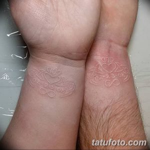 Фото парных белых тату на запястьях. Рисунки в виде сердец и дат, выполненные белыми чернилами.
