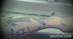 Фото эскиза татуировки на предплечье: изображение металлической конструкции, кинжала и абстрактных линий в минималистичном стиле.