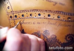 Фотография кожаного изделия с татуировкой, содержащей надпись "Success is never final, failure..." и растительный орнамент.