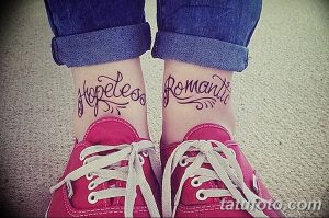 Фотография парных татуировок на лодыжках с надписями 'Hopeless Romantic'. Черные контурные татуировки на женских ногах.