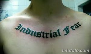 Фото тату: Черная татуировка надписи "Industrial Fear" готическим шрифтом на груди. Стильная и выразительная татуировка.