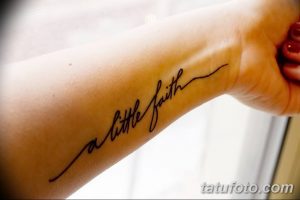 Фото тату: надпись 'a little faith' каллиграфическим шрифтом на запястье. Черно-белая татуировка, минималистичный дизайн.
