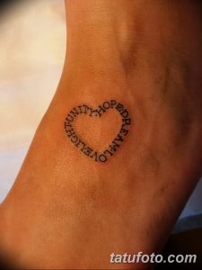 Фото тату: небольшое сердце, образованное словами 'Unity', 'Hope', 'Love', 'Family', на запястье. Минималистичный дизайн, черные чернила.