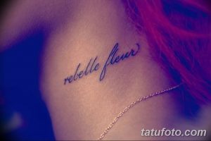 Фото тату: изящная надпись "rebelle fleur" на боку, выполненная каллиграфическим шрифтом. Подходит для девушек, ценящих красоту и индивидуальность.