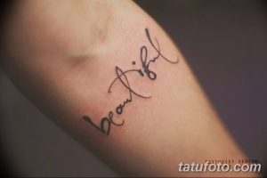 Фотография татуировки с надписью 'Beautiful', выполненной каллиграфическим шрифтом на руке.