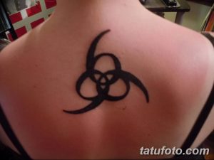 Черно-белое фото татуировки с символом группы Led Zeppelin на спине мужчины. Лаконичный дизайн и четкие линии.