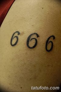 Фото тату: черная татуировка с числом '666' на плече. Простой, лаконичный дизайн, выполненный четкими линиями.
