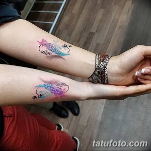 Фото парных акварельных татуировок на запястьях: перо с надписью 'alive' и отпечатком лапы. Размытые цвета, нежный дизайн.