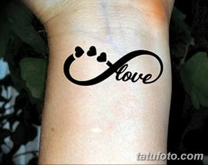 Фото тату: надпись "Love" в форме бесконечности с отпечатками лап, выполненная на запястье. Милый и трогательный рисунок татуировки.