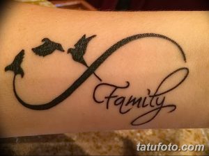 Фото тату со словом 'Family', заключенным в символ бесконечности, с изображением летящих птиц. Черно-белая татуировка, символ любви и семьи.